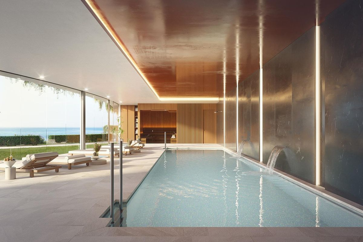 Luxe binnenzwembad met uitzicht op de oceaan en ontspannende ligstoelen, onderdeel van een bungalow in Benalmádena.