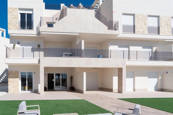 Exterior view of a modern 2-bed penthouse in Guardamar del Segura, showcasing terraces and landscaping.