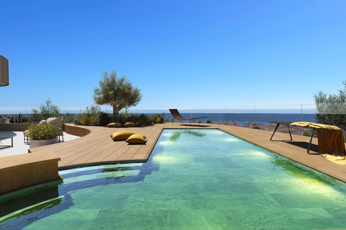 Een ander perspectief van het zwembadgebied met ligstoelen en levendige zitplaatsen, met uitzicht op de oceaan in Fuengirola.