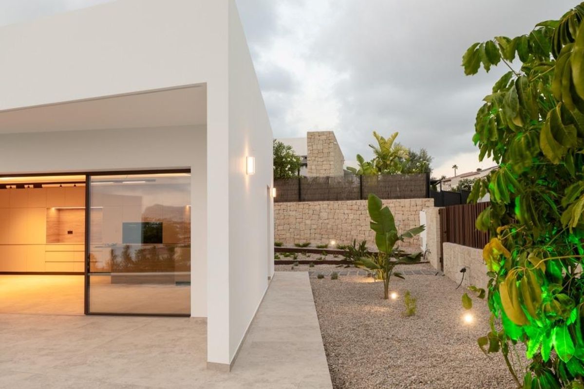 Avondbeeld van de tuin naast de villa, omgeven door weelderig groen.