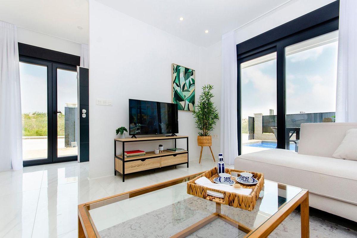 Heldere woonkamer in een 3-slaapkamer villa in Orihuela, met een tv en uitnodigend natuurlijk licht.