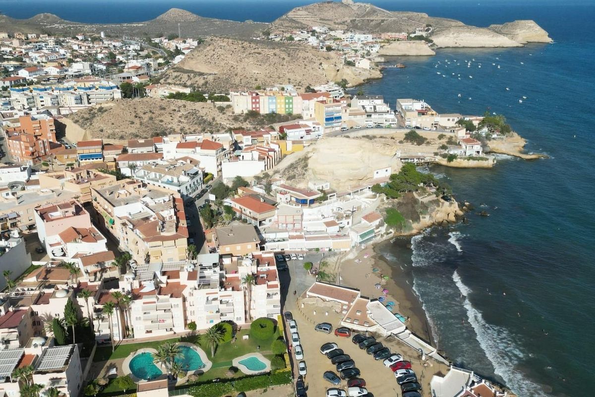 Kustzicht van San Juan de los Terreros, met kleurrijke gebouwen en het strandgebied.