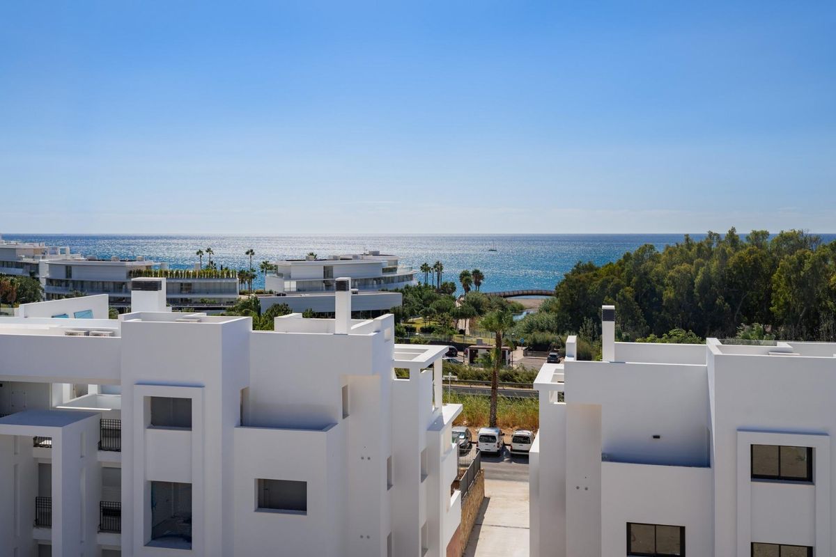 Uitzicht vanaf penthouse in Estepona, met de kust en nabijgelegen palmbomen.