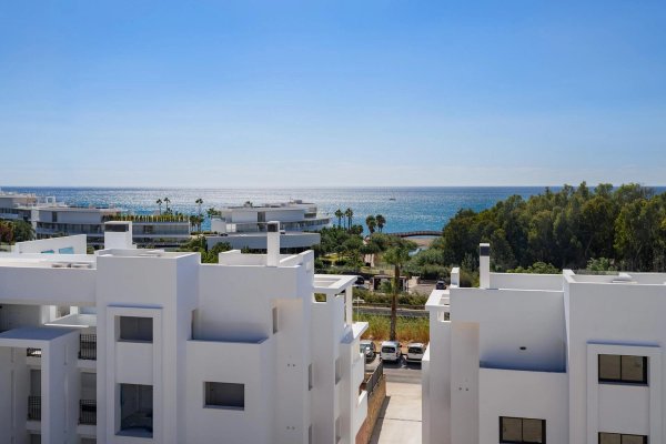 Uitzicht vanaf penthouse in Estepona, met de kust en nabijgelegen palmbomen.