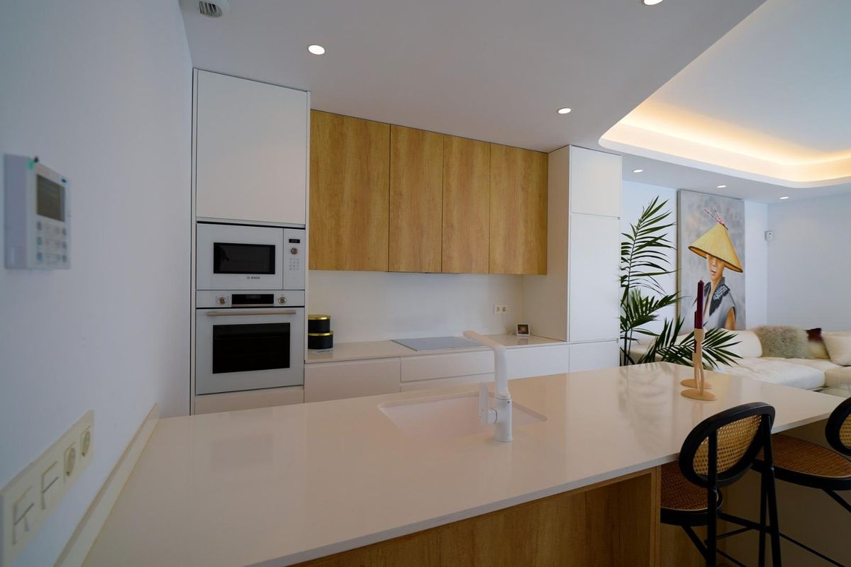 Moderne keuken met strakke kasten en een kookeiland in de 3-slaapkamer villa van Orihuela Costa.