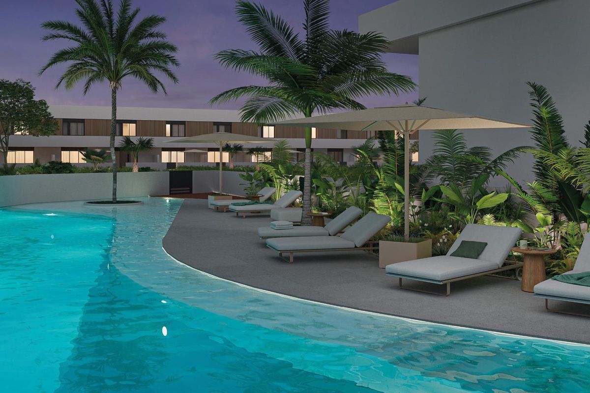 Ontspannende zwembadomgeving in Pilar de La Horadada, met ligstoelen en weelderige tropische planten.