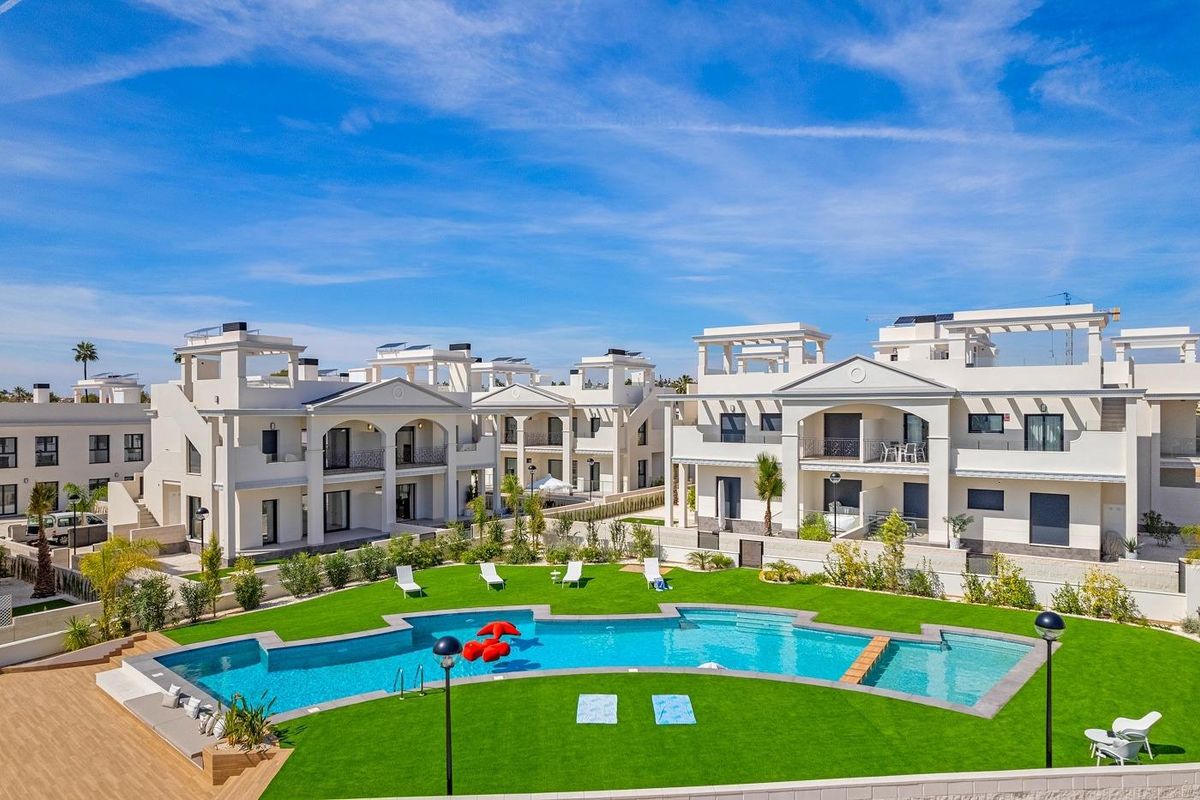 Luchtfoto van appartementencomplex in Rojales met een pool en aangelegde tuinen.