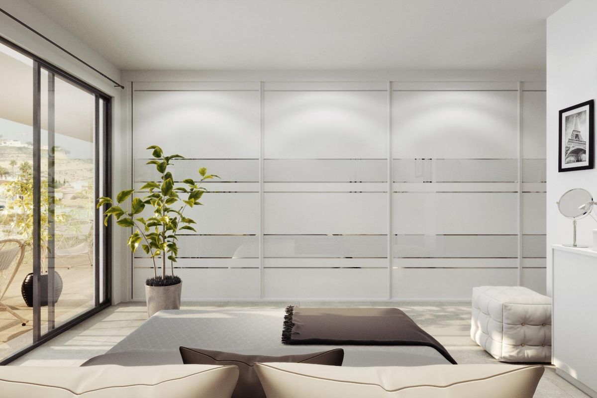 Minimalistisch ontwerp in een slaapkamer van de villa in Rojales, met glazen deuren en plantdecoraties.