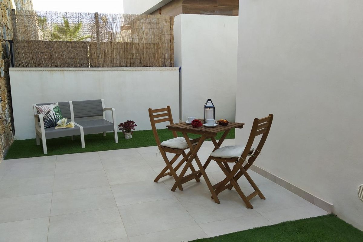 Charmante patio zithoek met een tafel en stoelen in de tuin van een villa in Orihuela Costa.