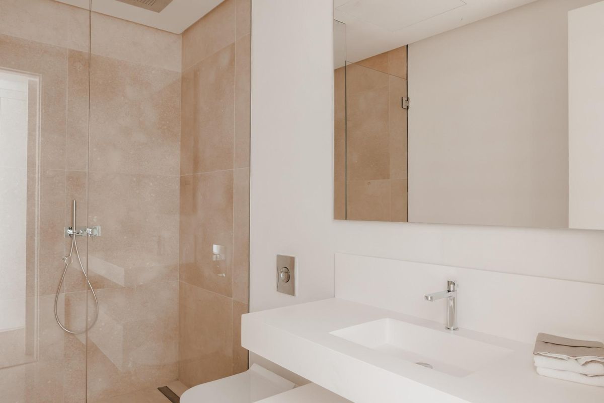 Moderne douchehoek in een verfijnde badkamer van een appartement in Benahavís, met hoogwaardige armaturen.