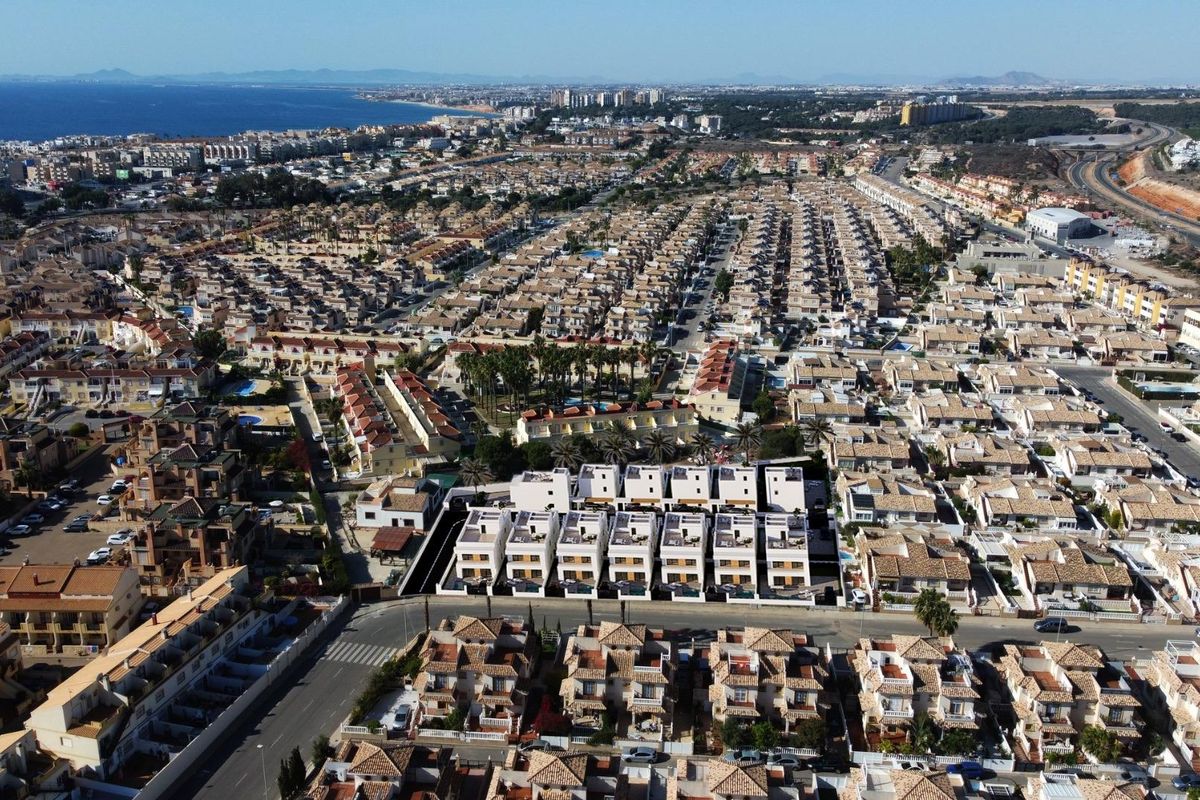 Brede luchtfoto van het gebied Orihuela Costa met een mix van townhouses en wooncomplexen.