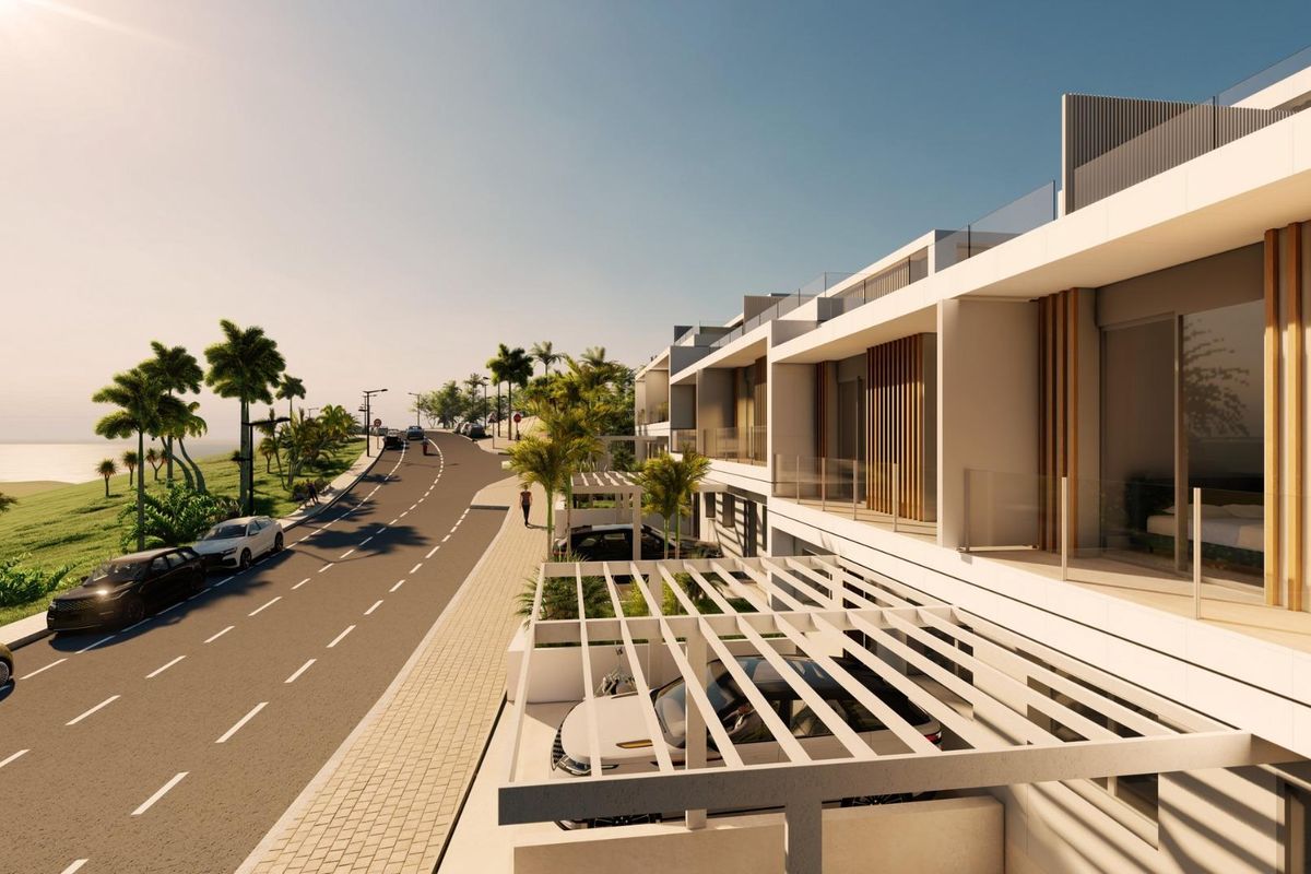 Strak wegzicht van een hedendaags townhousecomplex in Estepona, met palmbomen langs de straat.