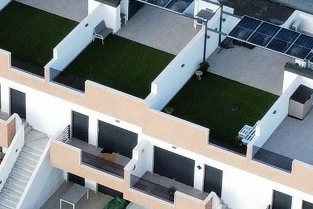 Luchtfoto van de bungalows met dakterrassen in Pilar de La Horadada, die de indeling van de gemeenschap laat zien.