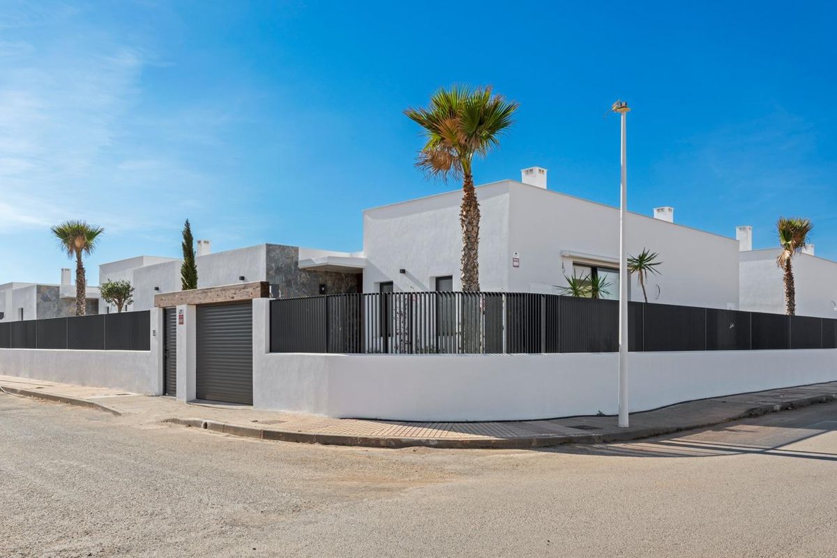Charmante vooraanzicht van de villa met palmbomen en een hek in Cartagena, Costa Calida.