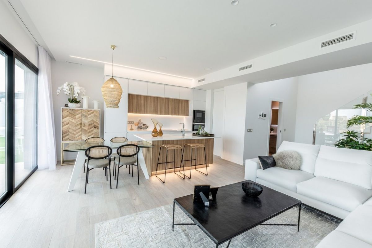Bright and open-plan living area of a villa in Costa Blanca, with a modern kitchen, dining area, and comfortable lounge.