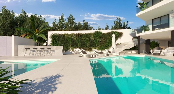 Prachtig zwembad met ligstoelen, omgeven door weelderig groen in Fuengirola, Costa del Sol.