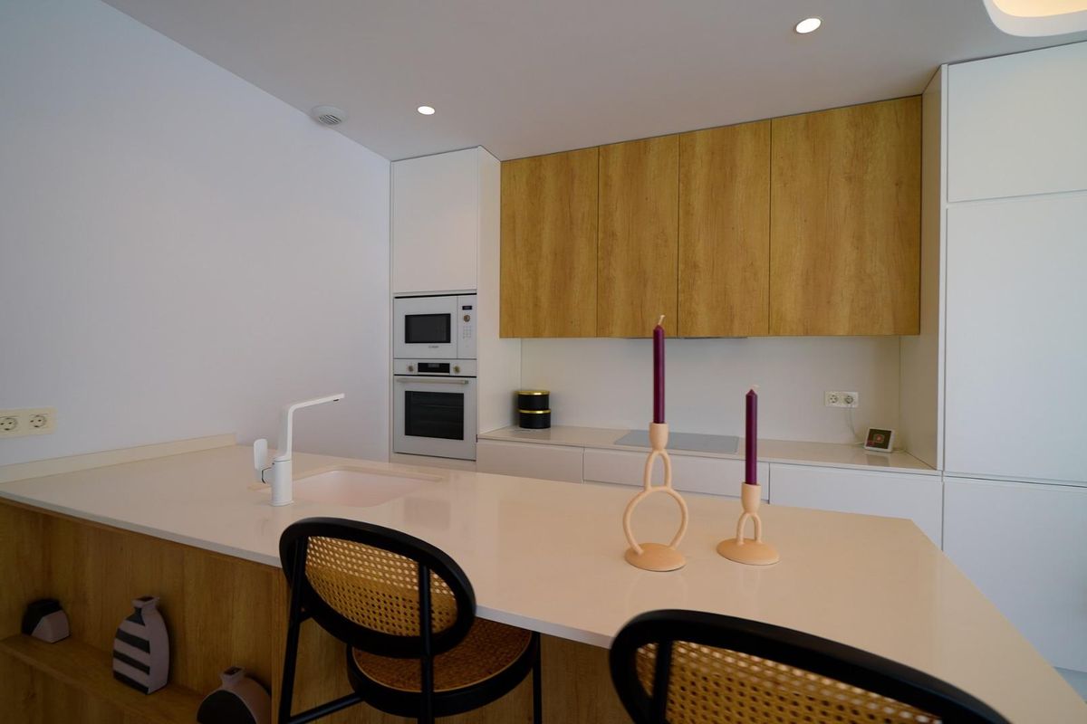 Strakke keuken met houten kasten en moderne apparaten in een 3-slaapkamer villa, Orihuela Costa, Spanje.