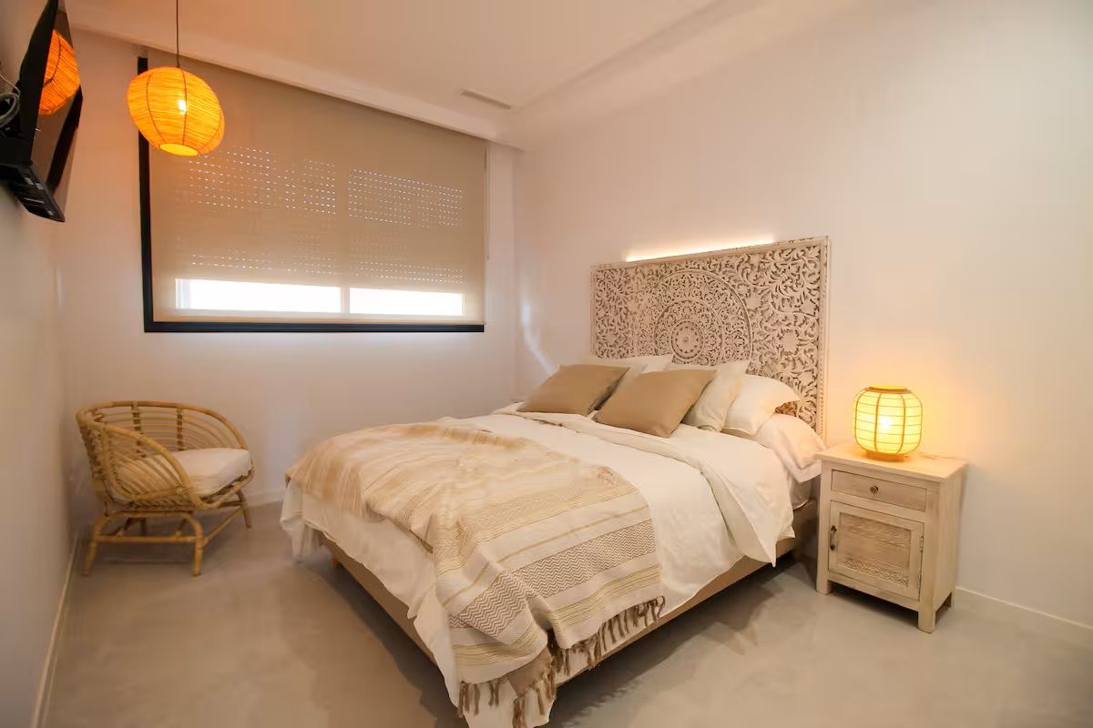 Elegante slaapkamer met ingewikkeld hoofdeinde en sfeerverlichting in de duplex in Finestrat.