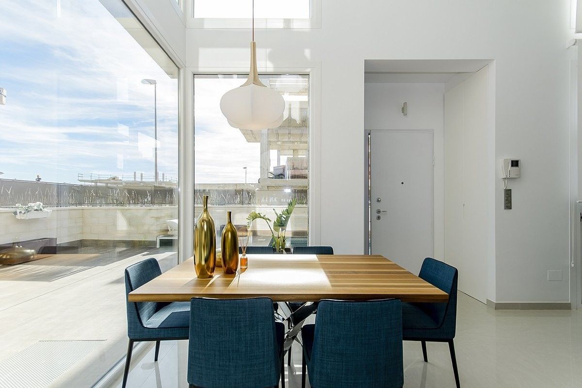 Heldere eetruimte met grote ramen en moderne decoratie in een villa in Los Montesinos, Costa Blanca.