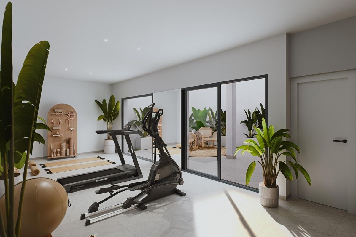 Ruime thuisgym met fitnessapparatuur en kamerplanten in een rijtjeshuis in Torre Pacheco, Spanje.