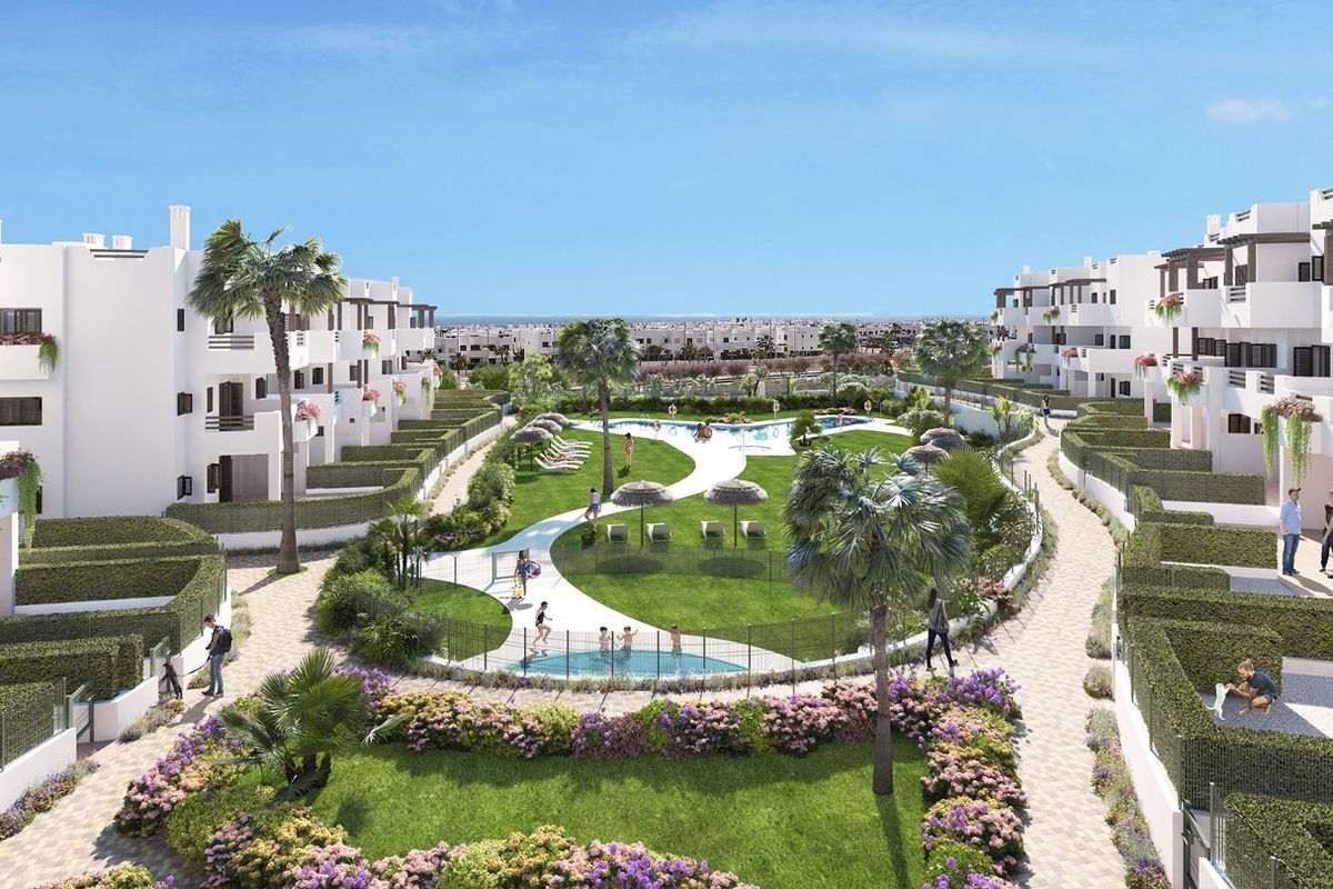 Luchtfoto van een modern wit appartementencomplex met zwembad en weelderige aangelegde tuinen in Mar de Pulpi, Spanje