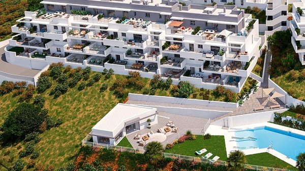 Luchtfoto van modern appartementencomplex in Manilva met weelderige tuinen en zwembad.