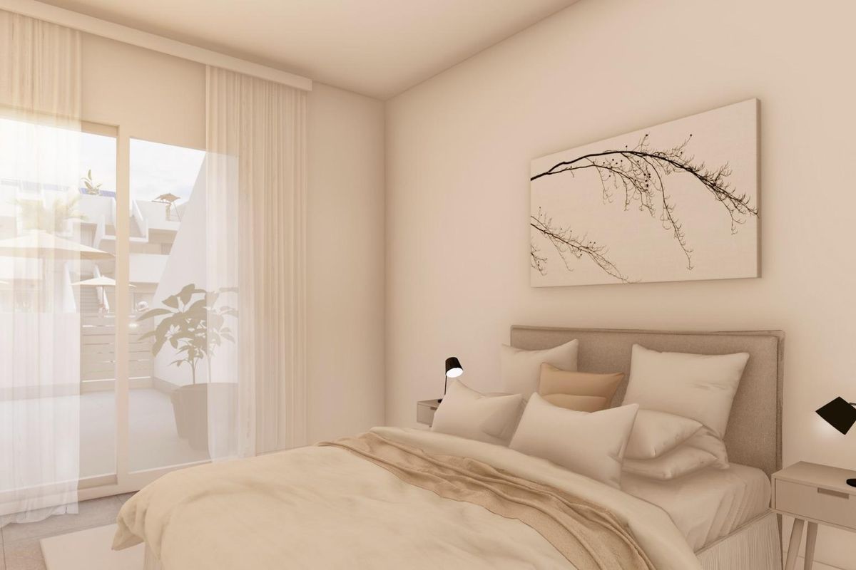 Heldere slaapkamer met een tweepersoonsbed en schuifdeuren naar het terras in het 3-slaapkamer appartement in Torre Pacheco.