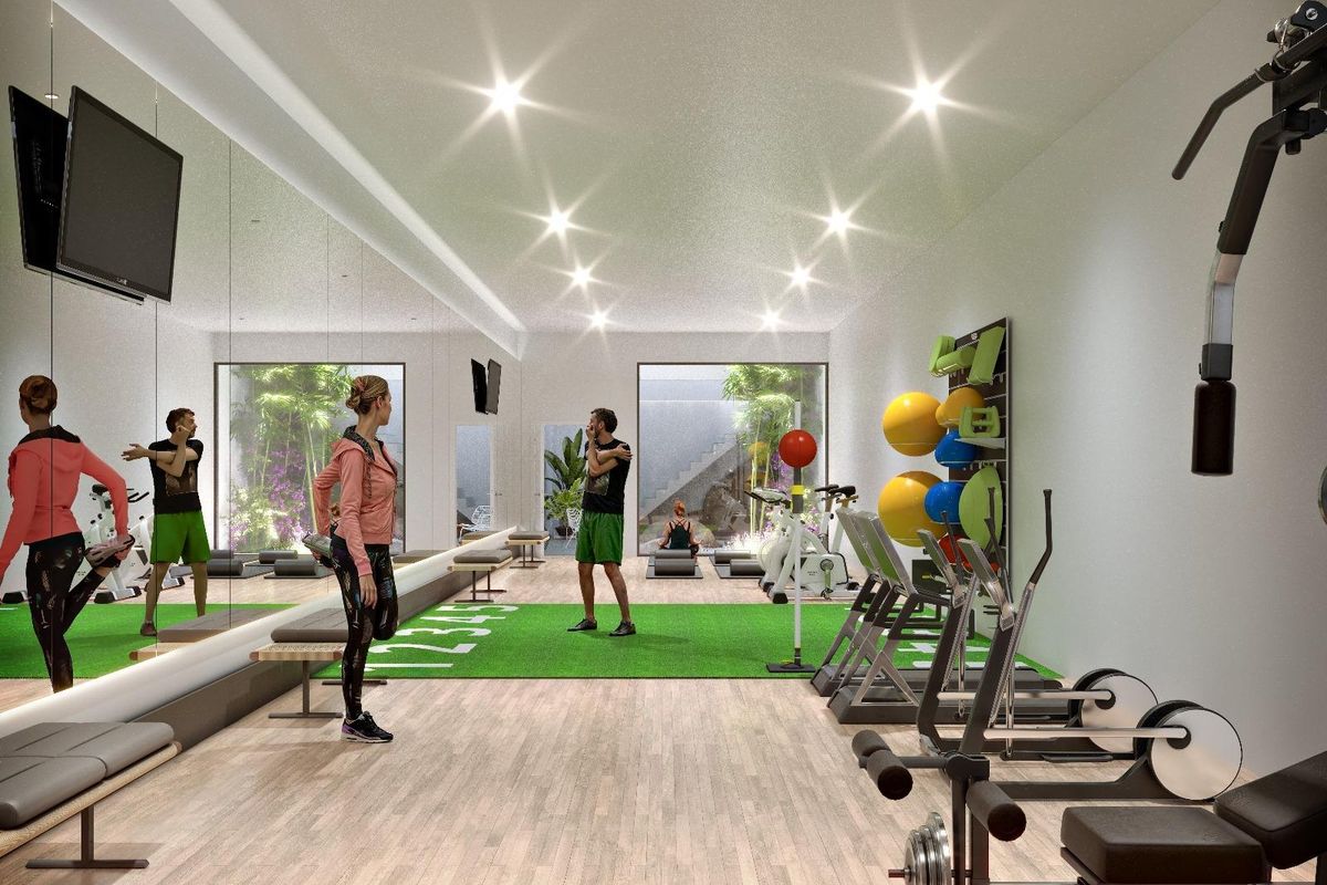 Moderne sportschool met fitnessapparatuur en levendige kleuren in een appartement op de begane grond in San Juan, Alicante.