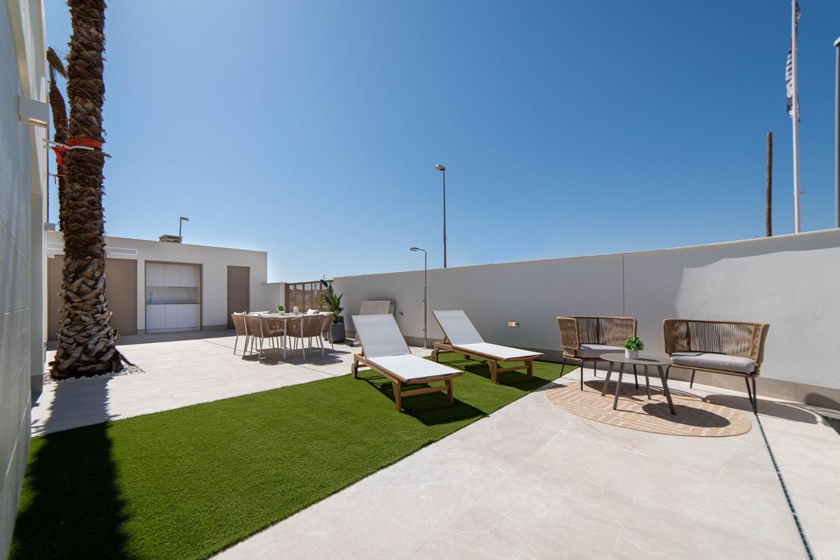 Ruimtelijk terras met ligstoelen en eetset bij een villa in Rojales, Costa Blanca Zuid.