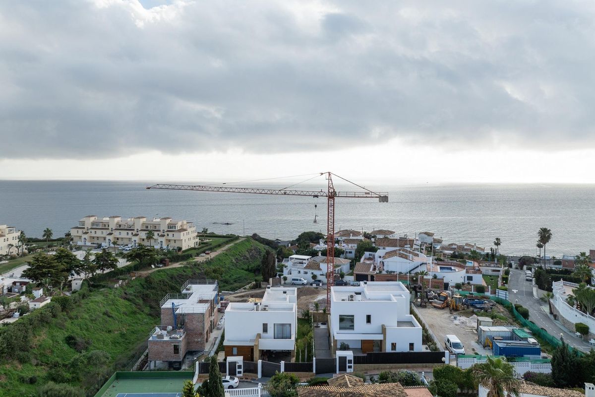 Bouwplaats in Mijas, Costa del Sol, met moderne villa's in aanbouw met uitzicht op de kust.