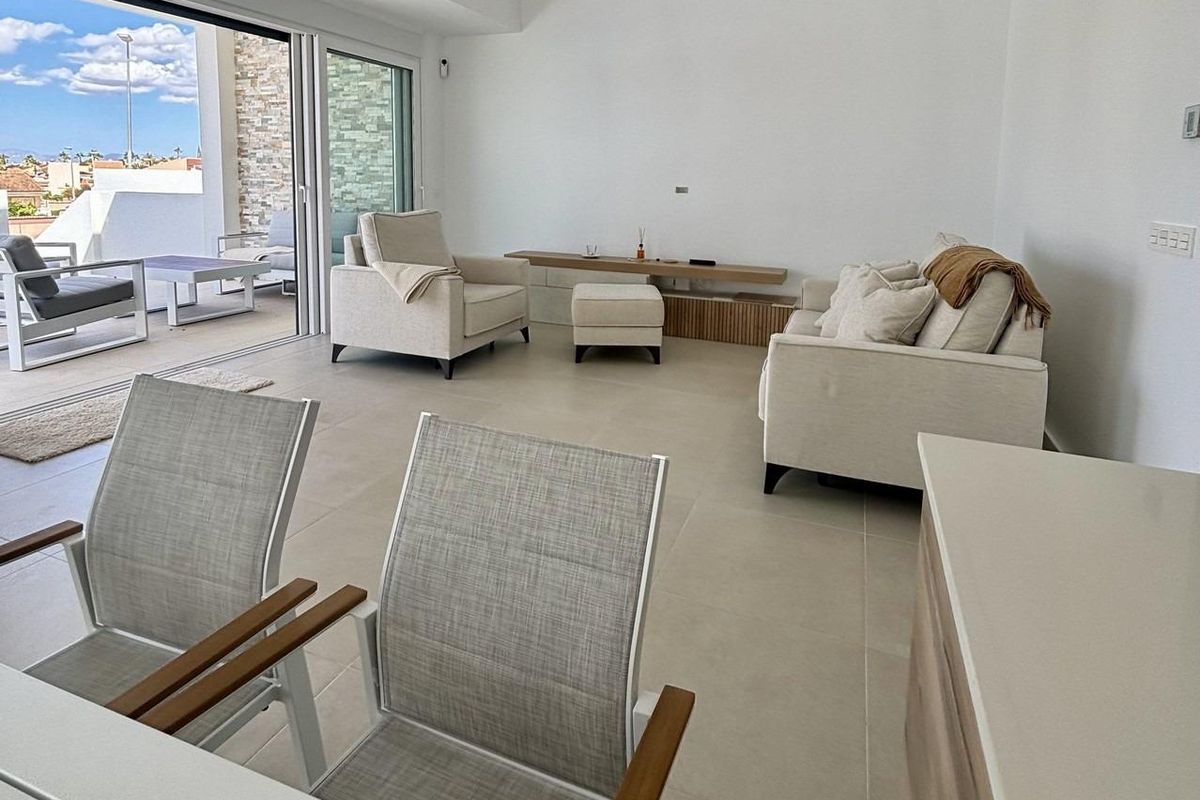 Heldere woonkamer met moderne meubels en toegang tot het terras in een villa in Benijofar.