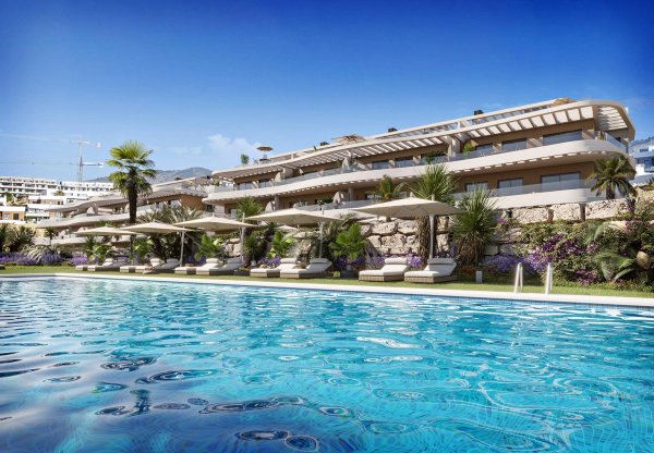 Buitenzijde van een luxe appartementencomplex met zwembad en palmbomen in Finestrat, Costa Blanca Noord.