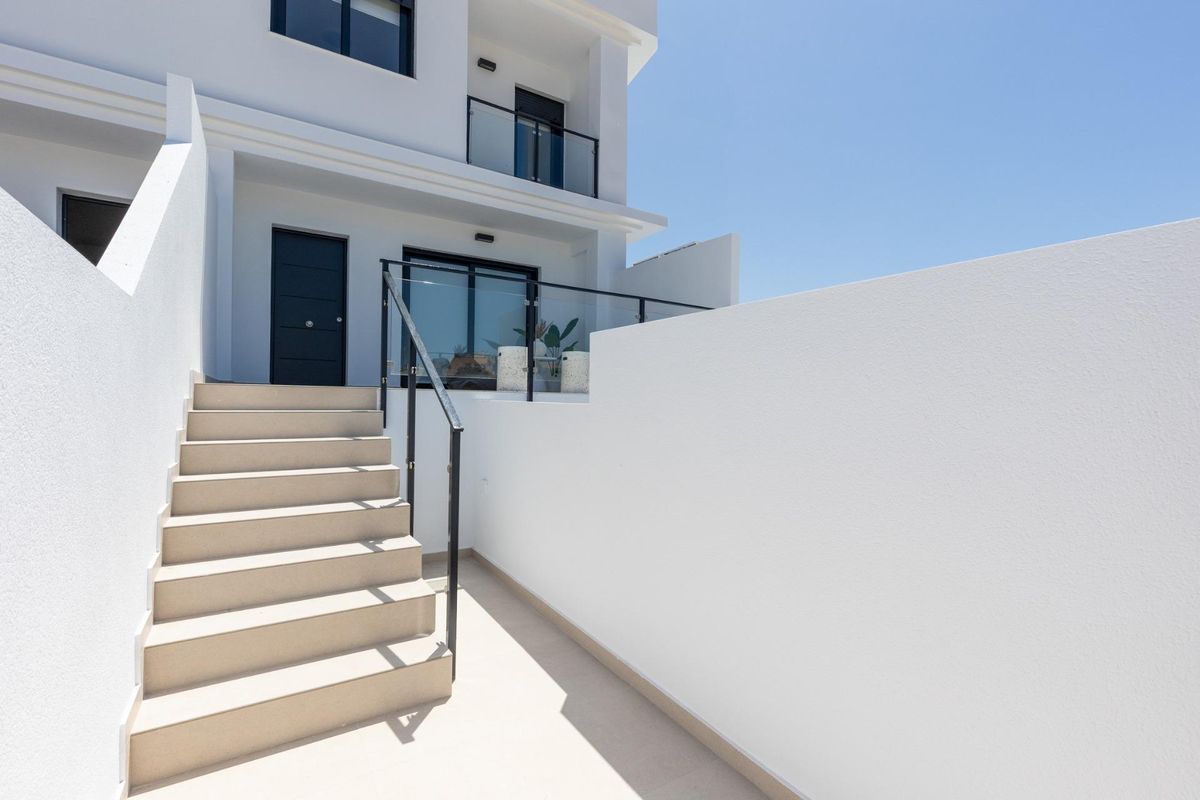 Trappen leidend naar de ingang van het moderne town house in Rafal, Costa Blanca Zuid, tegen een heldere lucht.