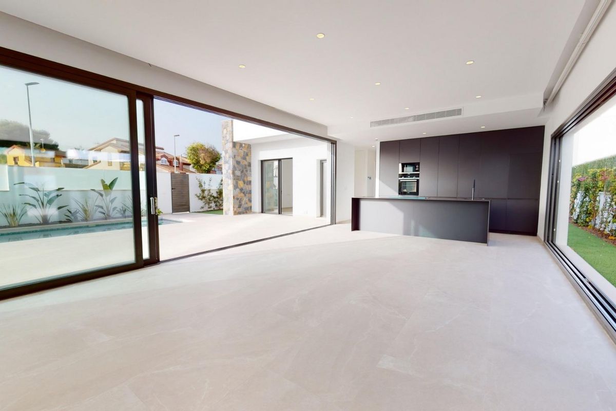 Helder open woonruimte met uitzicht op het terras en het zwembad in deze chique villa gelegen in Los Alcazares, Spanje.