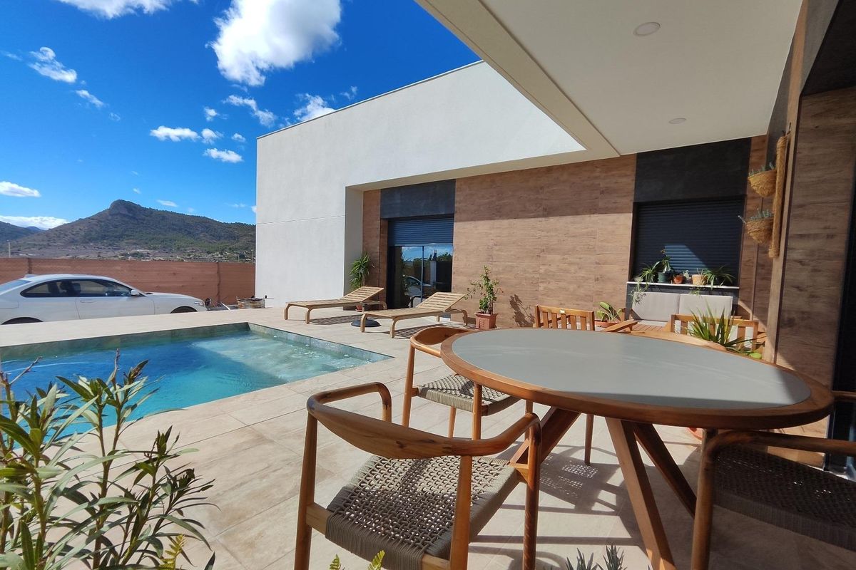 Dining area next to the pool in the Pinoso villa, offering stunning views of the mountains and surroundings.