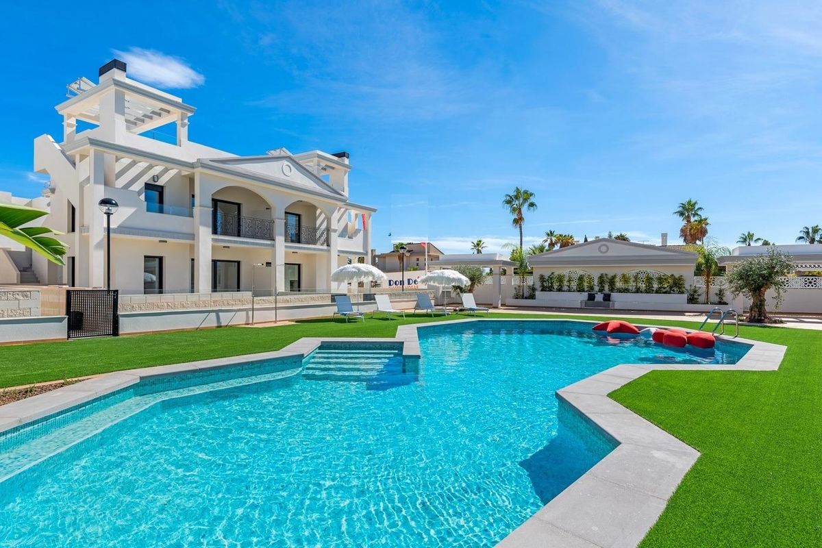 Heldere zwembaden met ligstoelen in een wooncomplex in Rojales, Costa Blanca Zuid, Spanje.