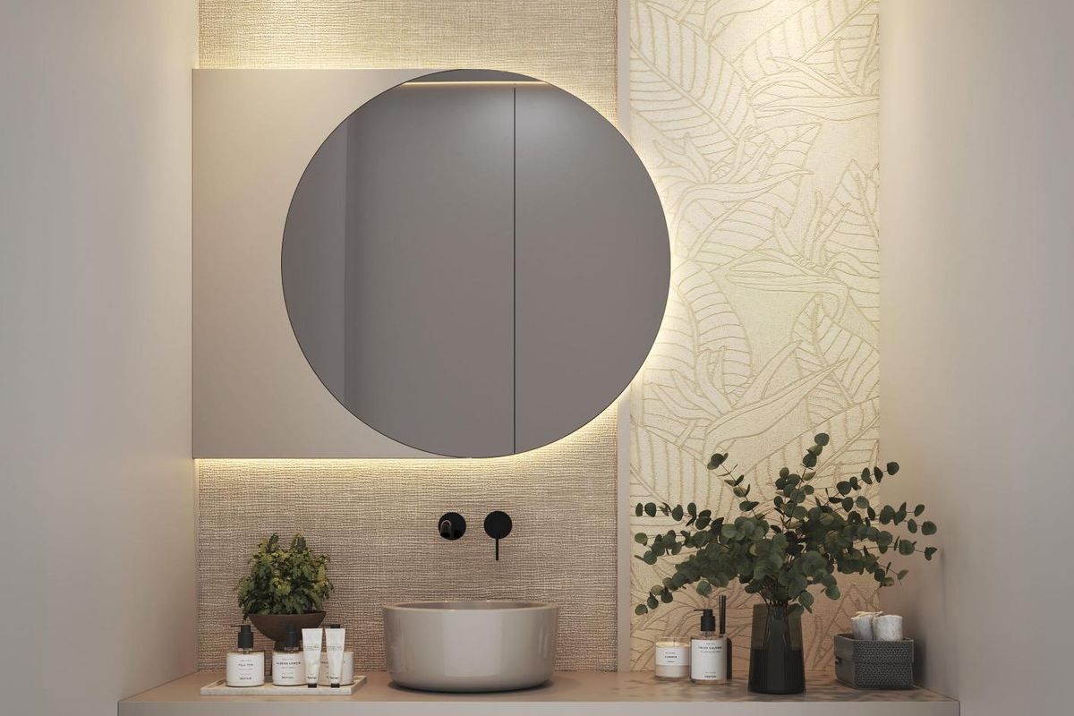 Moderne badkamer in een villa in estepona met een ronde spiegel, wastafel met aanrechtblad en accentverlichting.