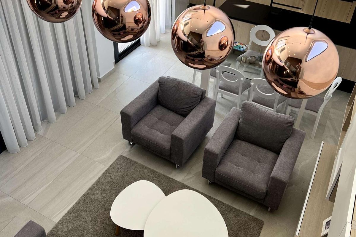 Stijlvolle woonkamer met moderne decoratie, grijze banken en elegante verlichting in Rojales, Spanje.