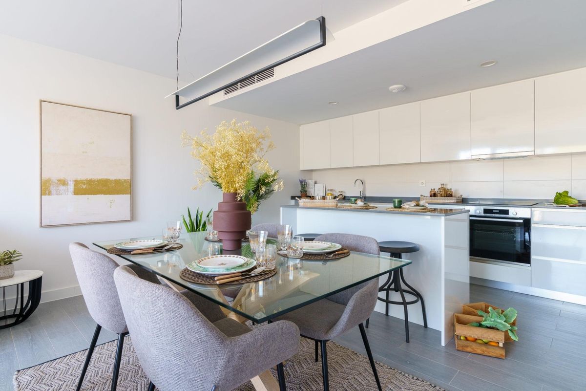 Eettafel gedekt voor gasten met uitzicht op de moderne keuken in het penthouse in Mijas.
