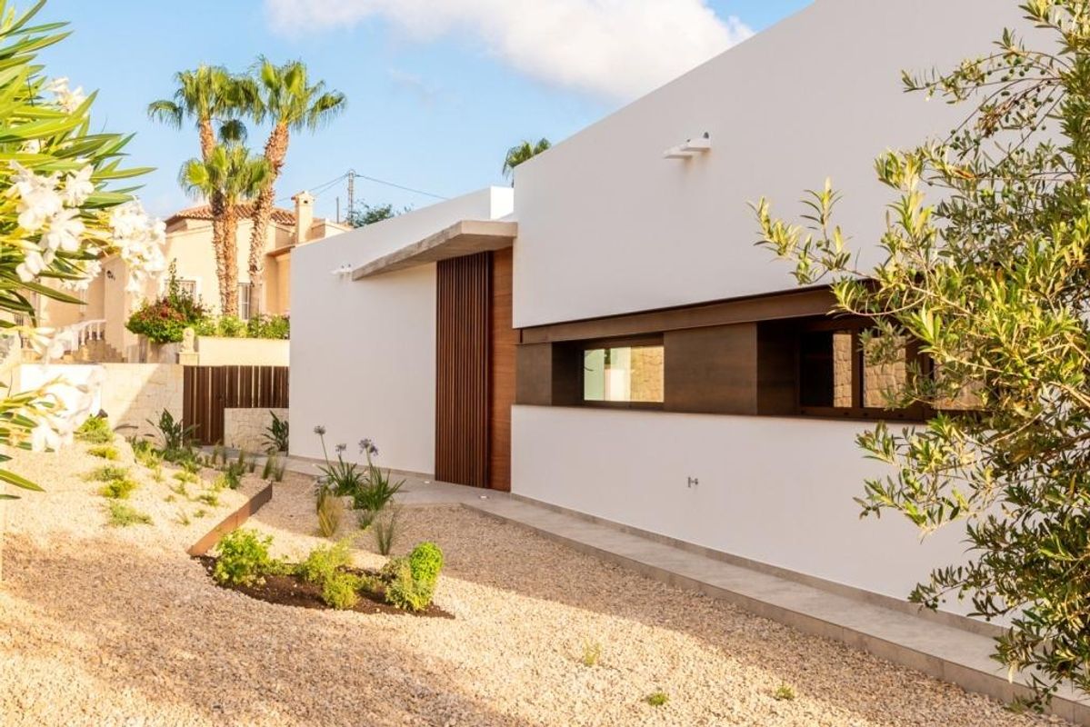 Stijlvolle ingang van de villa omgeven door een aangelegde tuin in Calpe.