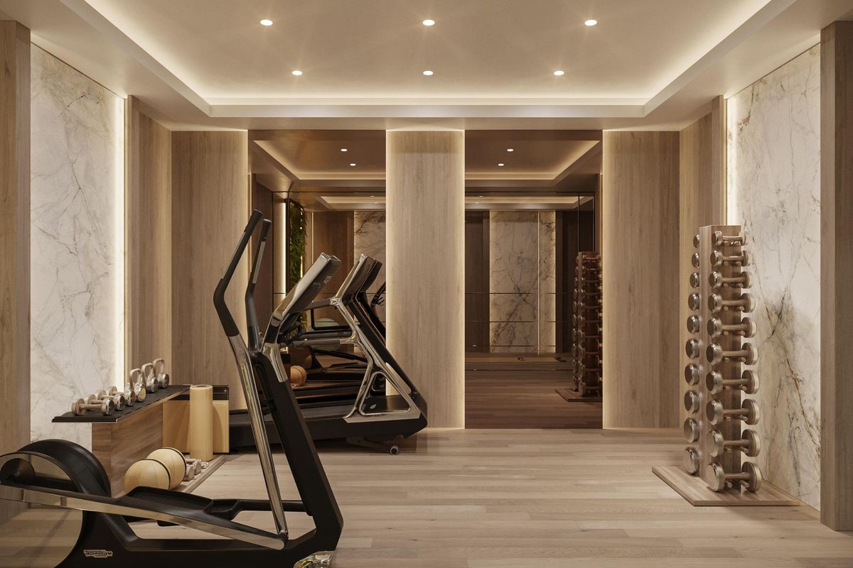 Moderne gym met loopbanden en apparatuur, met elegante hout- en marmerafwerkingen in Marbella, Costa del Sol.