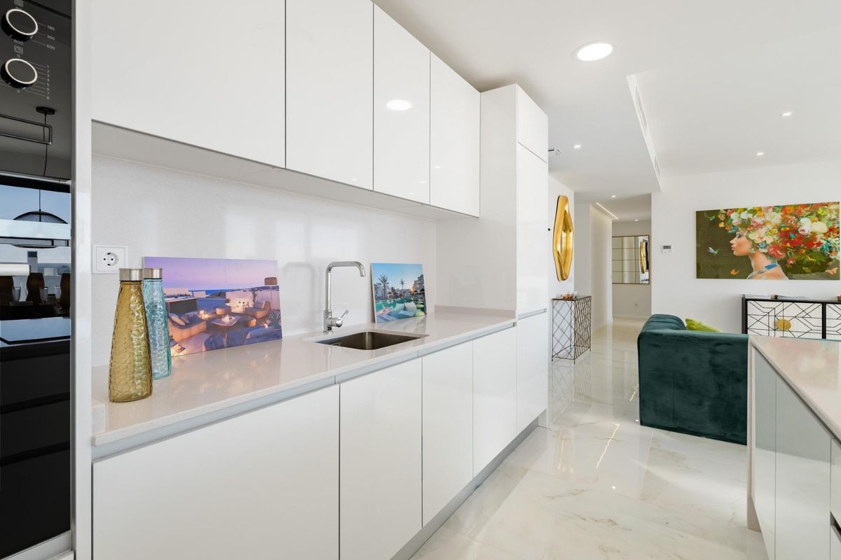 Contemporary keukenontwerp in penthouse in Estepona, met een strak aanrecht en moderne apparaten.
