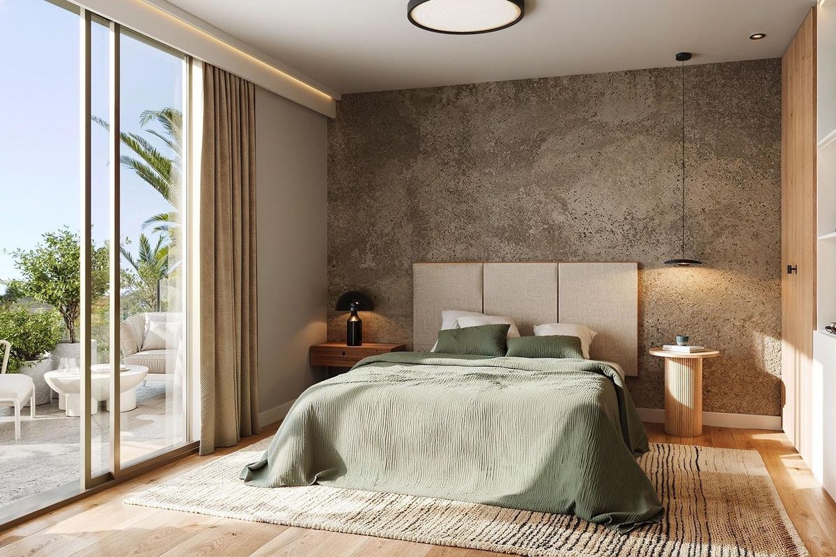 Stijlvolle slaapkamer met een gezellig bed en directe toegang tot een buitenzitruimte in een appartement in Mijas.