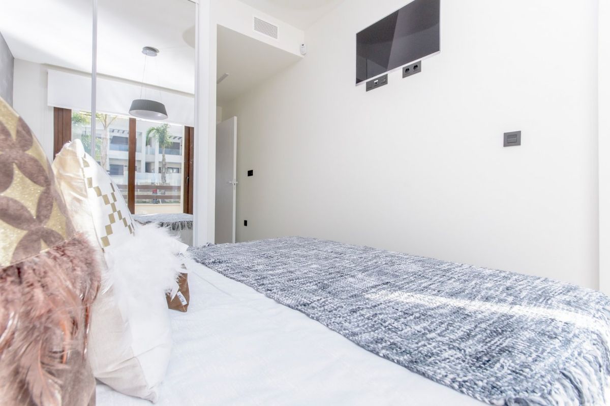 Helder slaapkamerhoek van een 2-slaapkamer appartement in Torrevieja met moderne decoraties en natuurlijk licht.