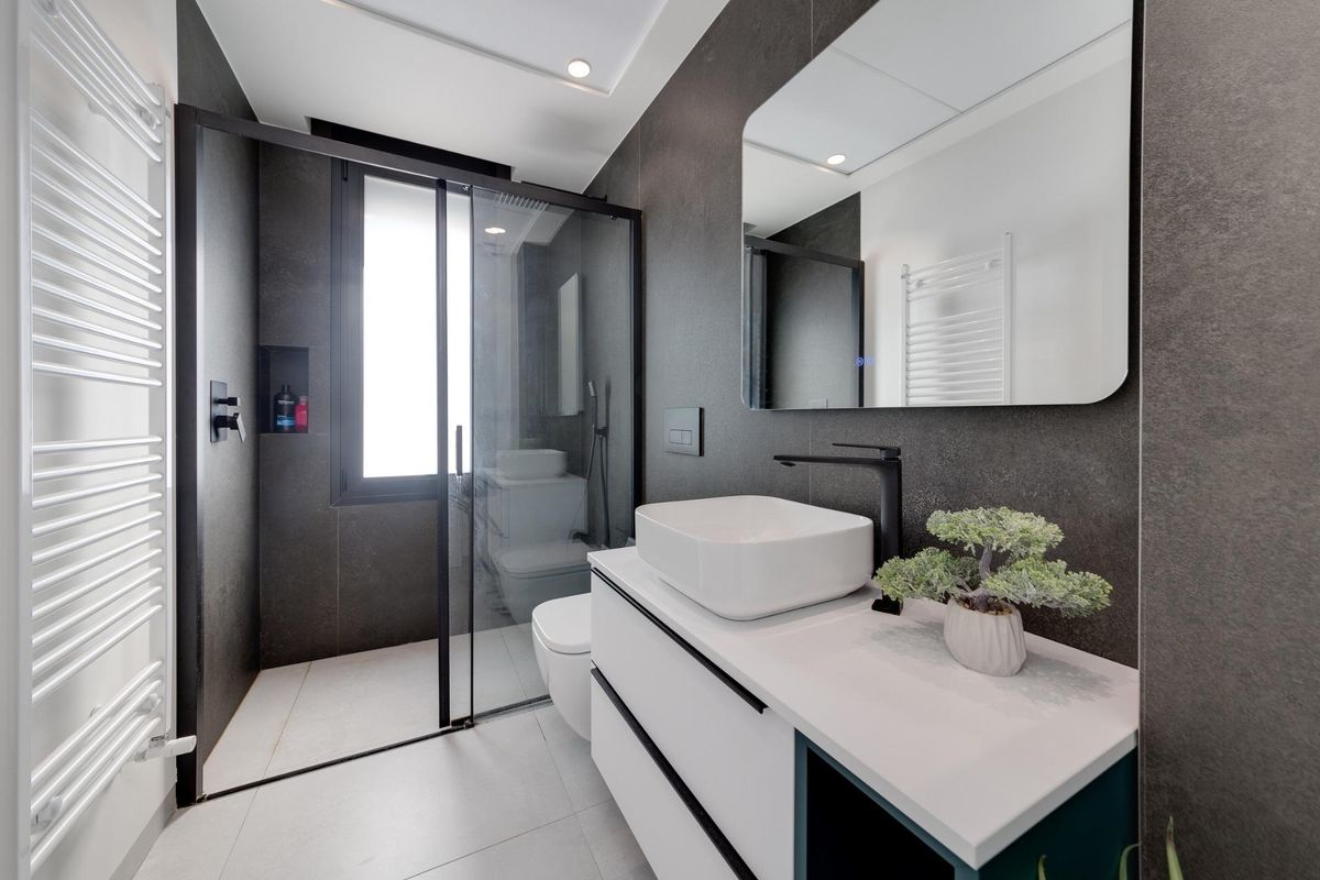 Moderne badkamer met een glazen douche en stijlvolle wastafel in een 3-slaapkamer villa in Pilar de La Horadada.
