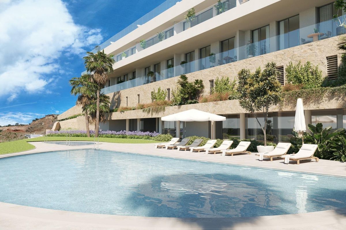 Buitenzwembad met ligstoelen in een stijlvol townhouse-complex, Fuengirola, Costa del Sol.