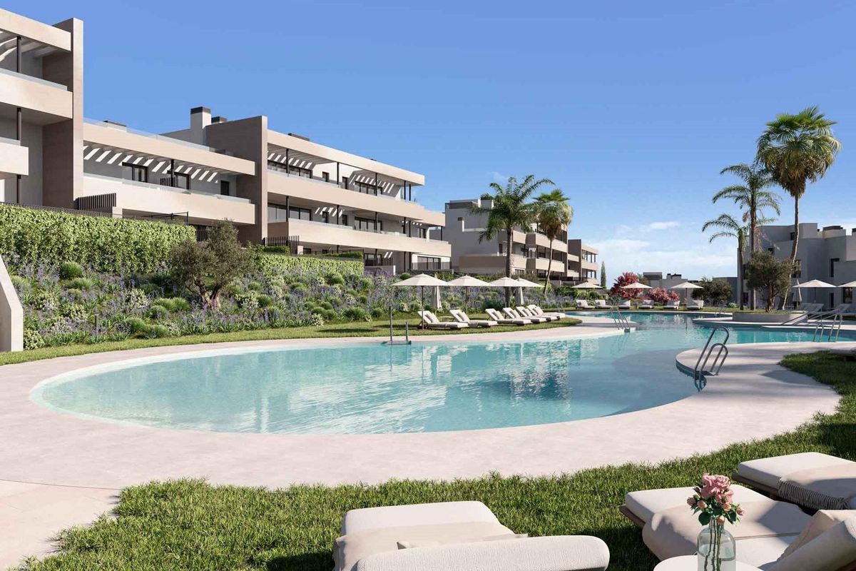 Zwemgebied omringd door groene tuinen en palmbomen bij het appartementencomplex in Casares.