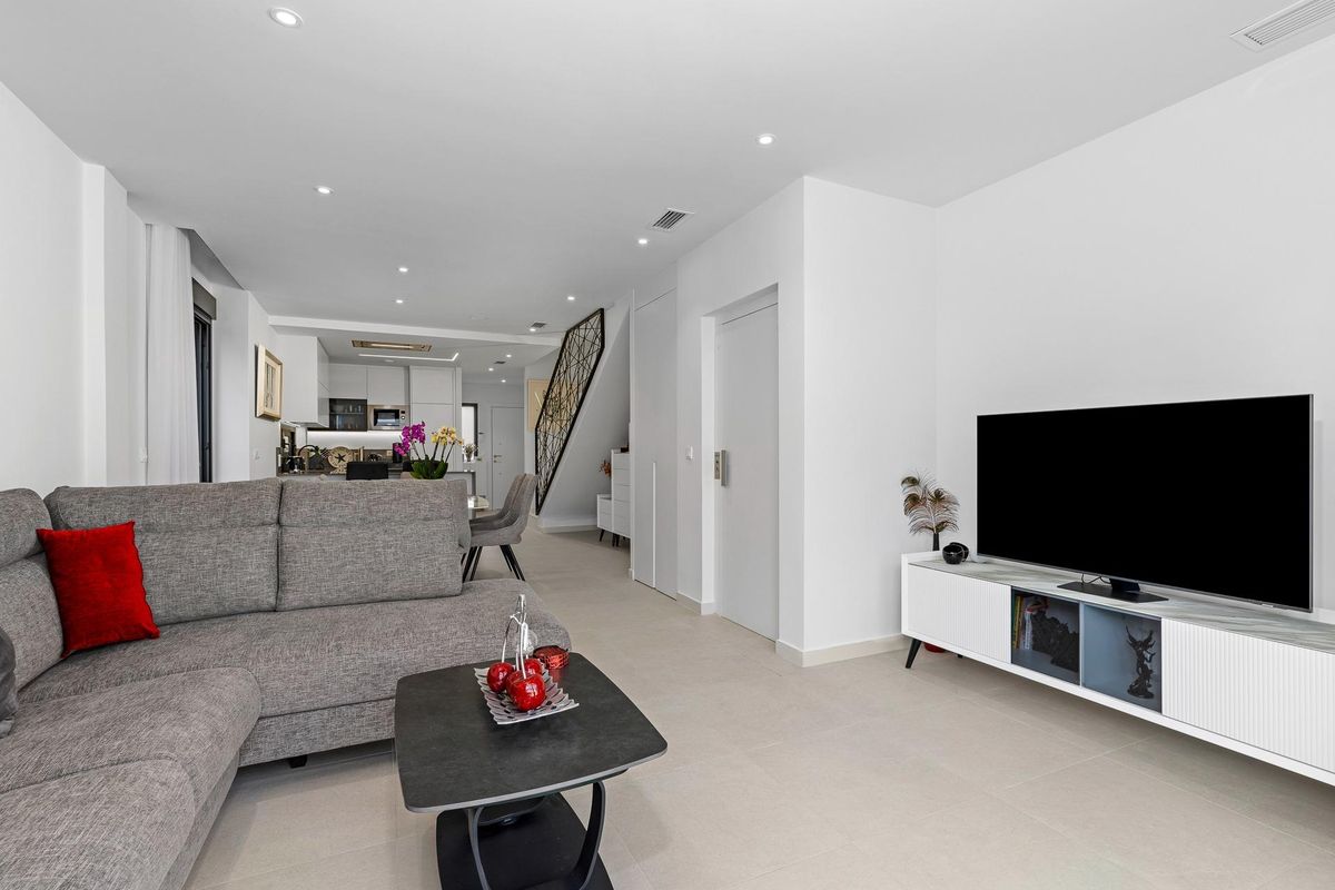 Heldere woonkamer in een 4-slaapkamer townhouse in Guardamar del Segura, stijlvolle meubels met uitzicht op de keuken.