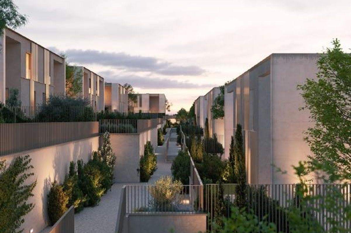 Avondzicht op rijtjeshuizen in Godella, met verlichte paden en aangelegde omgeving.