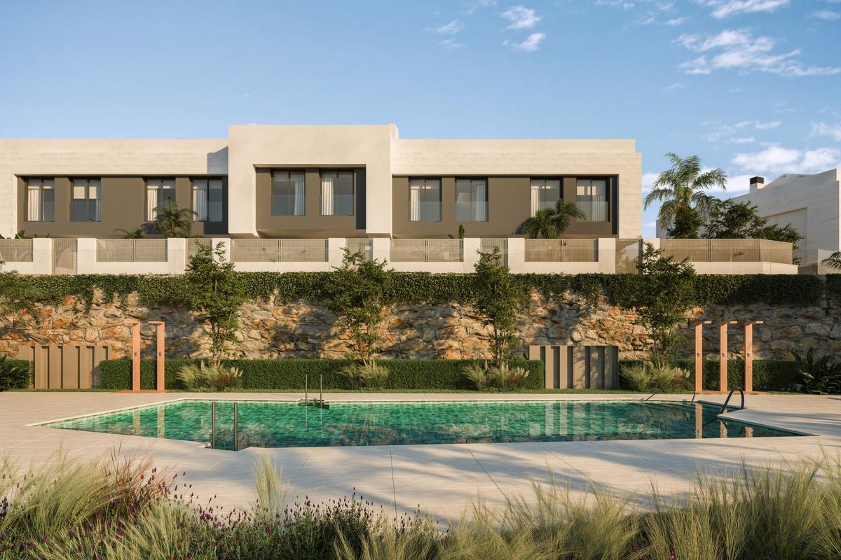Exterieur van een moderne 3-slaapkamer town house met zwembad in Mijas, Costa del Sol. Aangelegde tuin met stenen muur. Gemeenschappelijk zwembad.